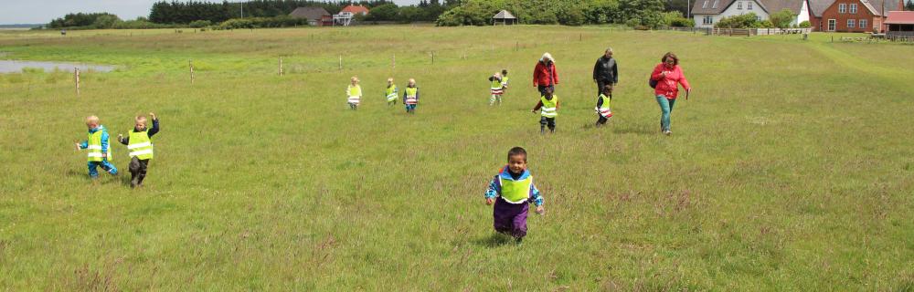 Løbende børn på græsmark